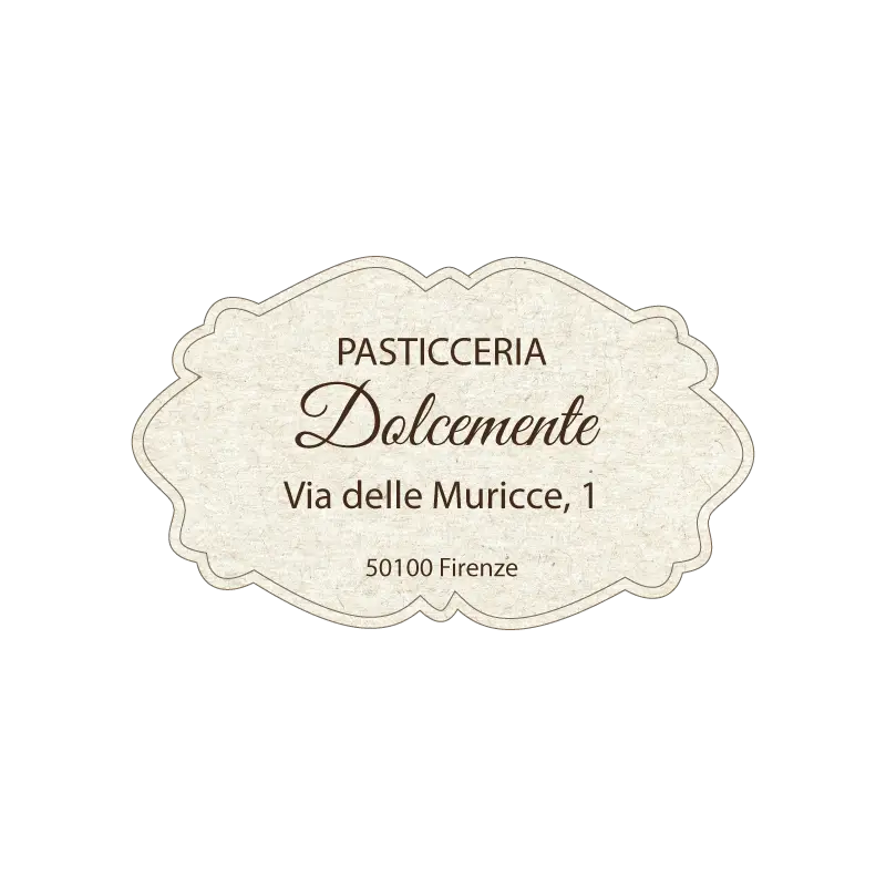 Etichetta ovale bianca con scritta dorata “Il Cantuccio” e spiga di grano stilizzata, indicante specialità di biscotti artigianali e indirizzo a Pisa.